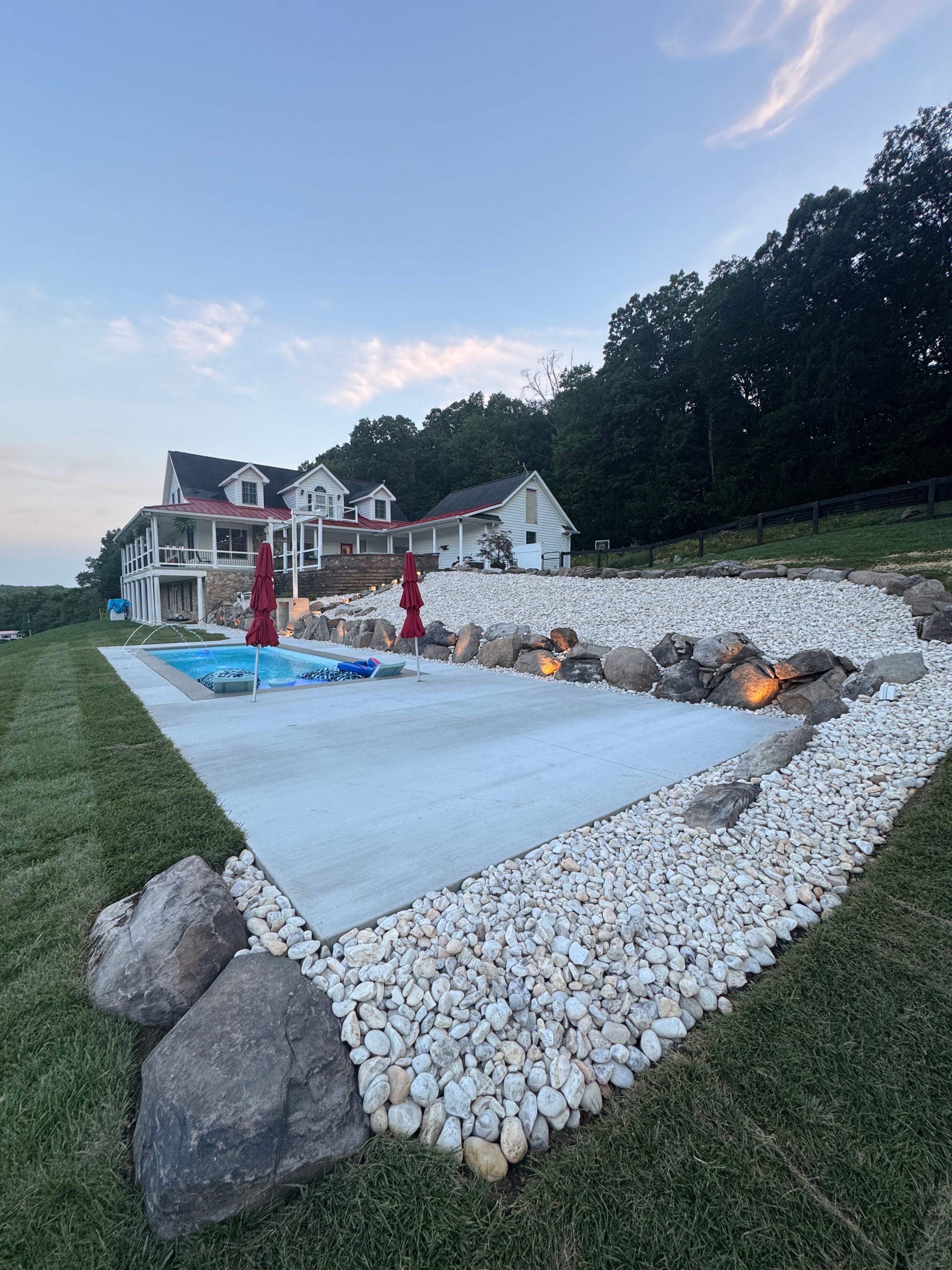 LandPro pool with boulder landscaping and wide open yard