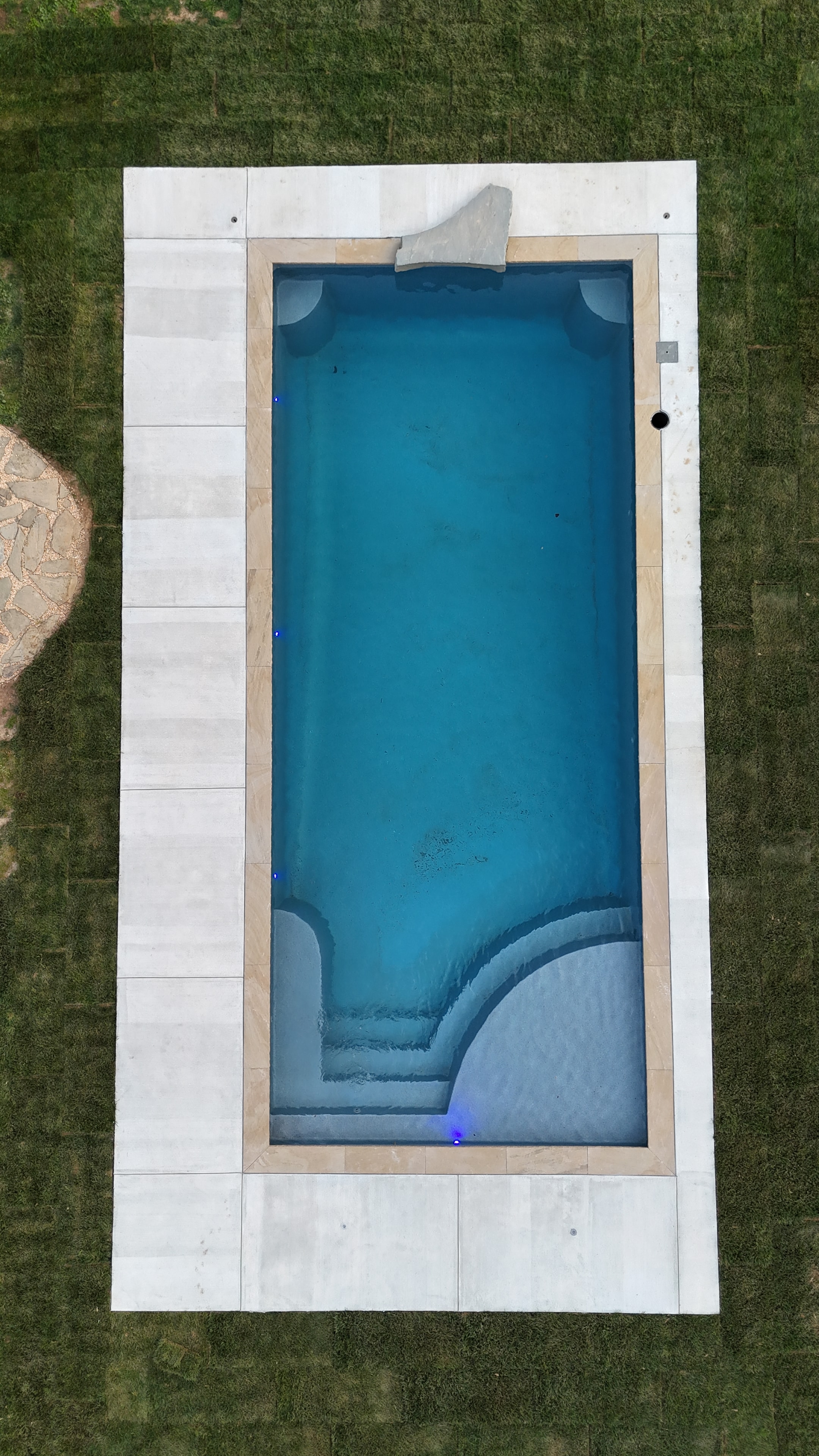 Light Up the Night — aerial daytime shot of pool with blue LED lights and stone coping detail